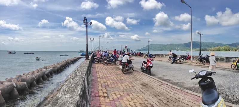 Xe máy đậu dọc con đường ven biển với khối chắn sóng tại bến Bãi Vòng, đảo Phú Quốc.