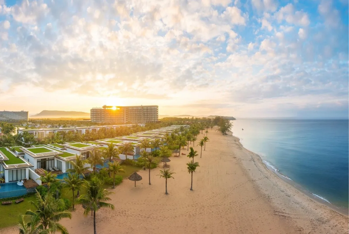Toàn cảnh khu resort ven biển với hàng cây dừa và biệt thự dọc bãi cát lúc bình minh ở Phú Quốc